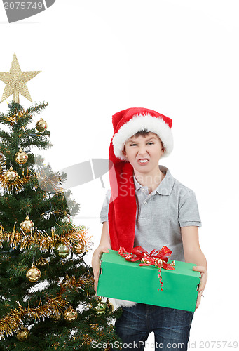 Image of happy boy in santa hat surprised by christmas present