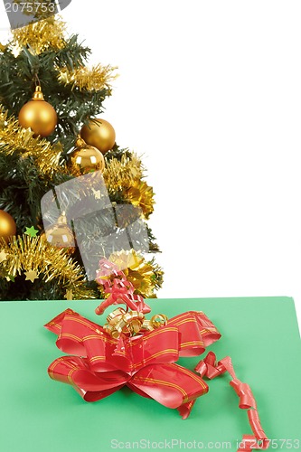 Image of yellow decorated christmas tree  and gift with red ribbon