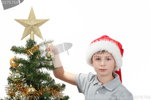 Image of Boy with santa hat decorates the Christmas tree