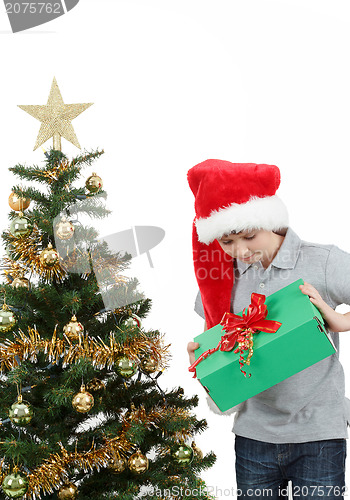 Image of happy boy in santa hat surprised by christmas present