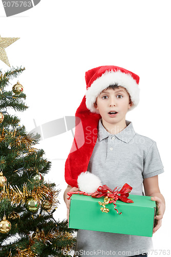 Image of happy boy in santa hat surprised by christmas present
