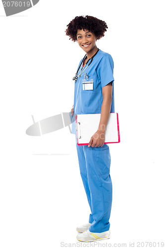 Image of Medical expert posing sideways, holding clipboard