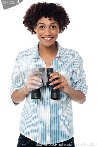 Image of Smiling afro american woman holding binocular