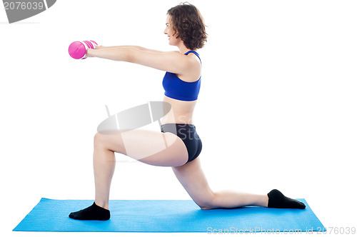 Image of Woman exercising with dumbbells, arms outstretched