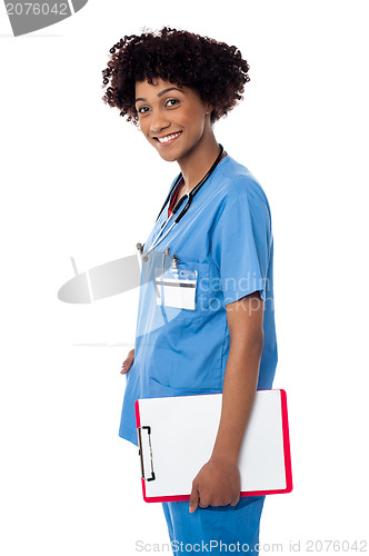 Image of Smiling medical professional holding blank clipboard