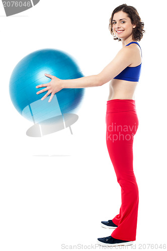 Image of Fit woman posing with big blue exercising ball