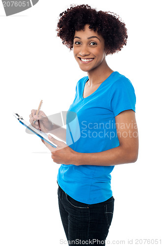 Image of Young lady documenting instructions on clipboard
