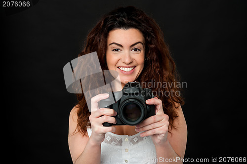 Image of Cheerful woman holding newly launched camera