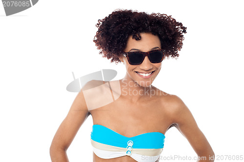 Image of Smiling curly haired bikini model in dark shades