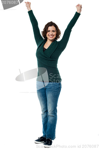 Image of Jubilant woman with raised arms celebrating victory