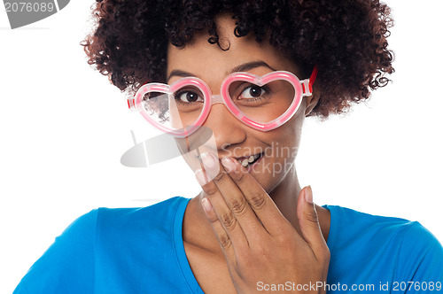 Image of Young model in heart shaped frame stifling her giggle