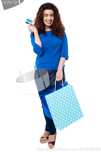 Image of Shopaholic woman holding shopping bags and credit card