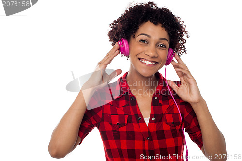 Image of Smiling woman with pink headphones on