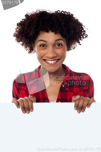 Image of Charming woman holding blank whiteboard