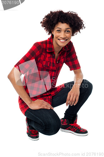 Image of Smiling female model in squatting posture