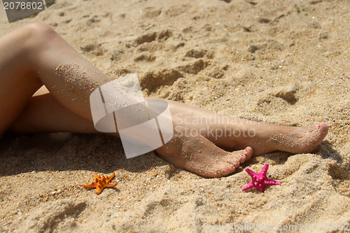 Image of Beautiful female legs on the beach 