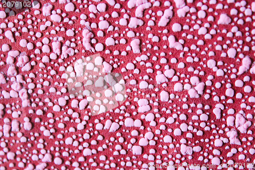 Image of Pink pimples on a red background