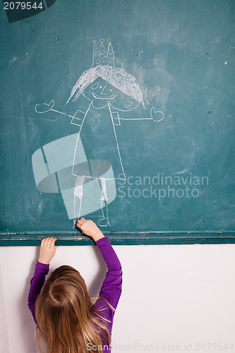 Image of Young girl drawing on chalkboard