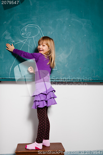 Image of Young girl drawing on chalkboard