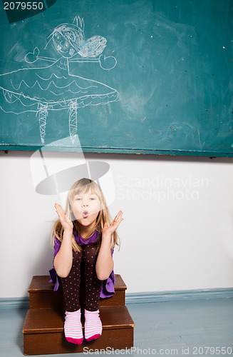 Image of Young girl blowing kiss in classroom