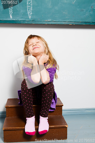 Image of Smiling young girl in front of chalkboard