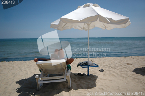 Image of Man, umbrella and sunbed