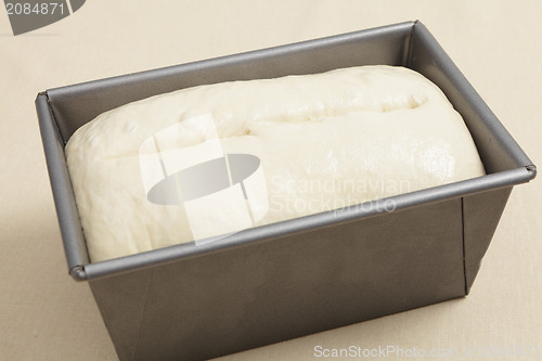 Image of Risen bread dough in a tin