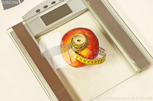 Image of bathroom scales with measure and apple