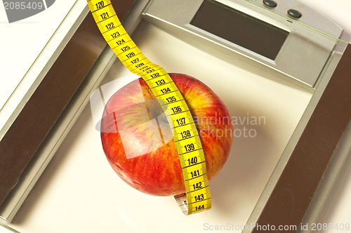 Image of bathroom scales with measure and apple