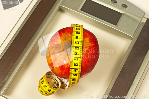 Image of bathroom scales with measure and apple