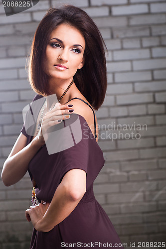 Image of beautiful girl posing against brick wall