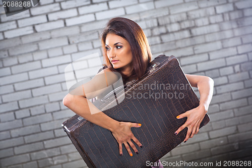 Image of beautiful thief girl with vintage suitcase waiting at the statio