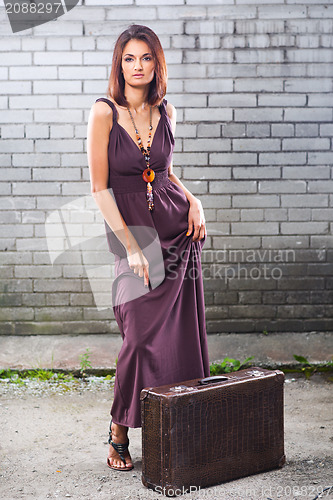 Image of beautiful lady with vintage suitcase waiting at the station