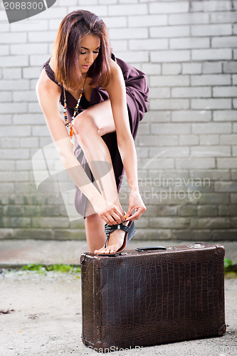 Image of beautiful lady  correcting a fastener on her shoe