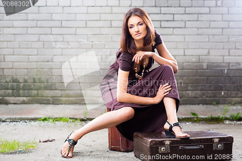 Image of beautiful lady with vintage suitcase waiting at the station