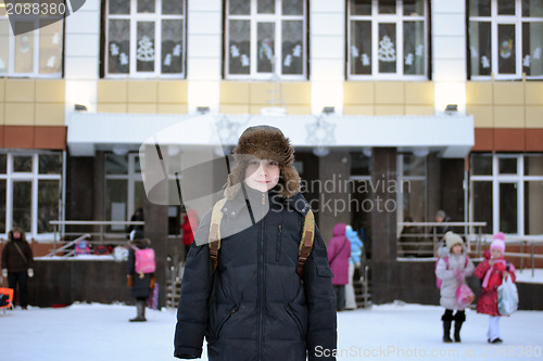 Image of The boy costs against school in the winter
