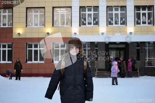 Image of The boy costs against school in the winter