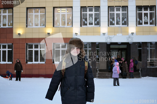 Image of The boy costs against school in the winter