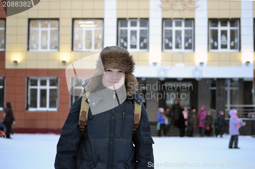 Image of The boy costs against school in the winter