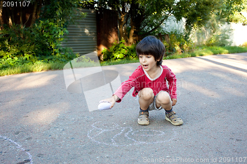 Image of boy drawing on asphalt