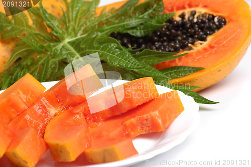 Image of Ripe papaya and slices with seeds and green leaf isolated on a w