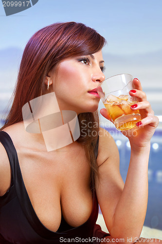 Image of brunette woman with glass of whisky