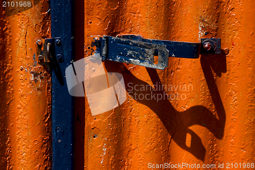 Image of blue safety lock in a red metal wall