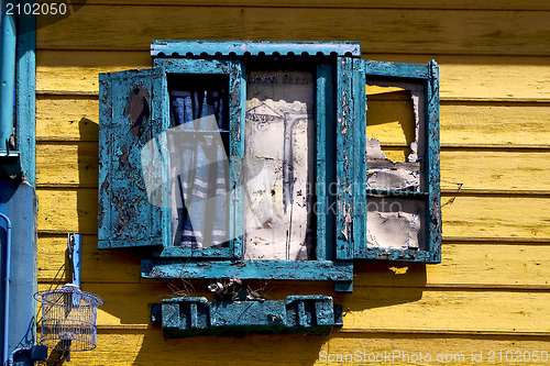 Image of blue wood venetian blind and a yellow wall 