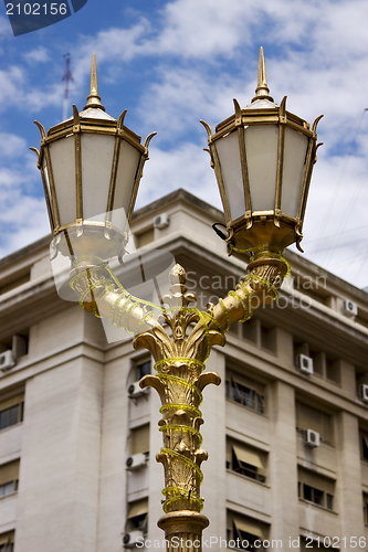 Image of  gold street lamp and a  palace 