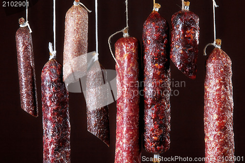 Image of various hanging salami sausages