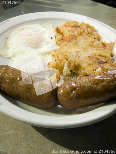 Image of fried eggs over easy pork sausages home fried potatoes breakfast