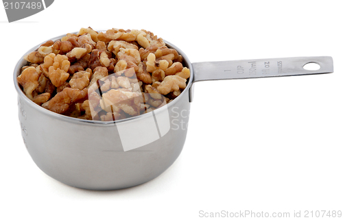 Image of Chopped walnuts presented in an American metal cup measure