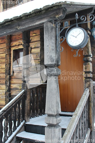 Image of Wooden porch of the wooden house with clock