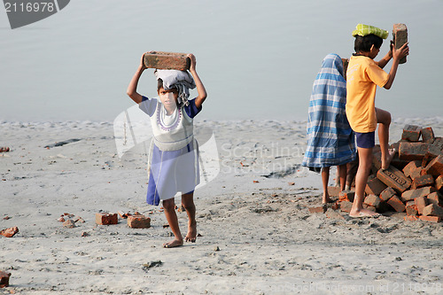 Image of Child workers carry bricks carrying it on his head in Sonakhali, West Bengal, India